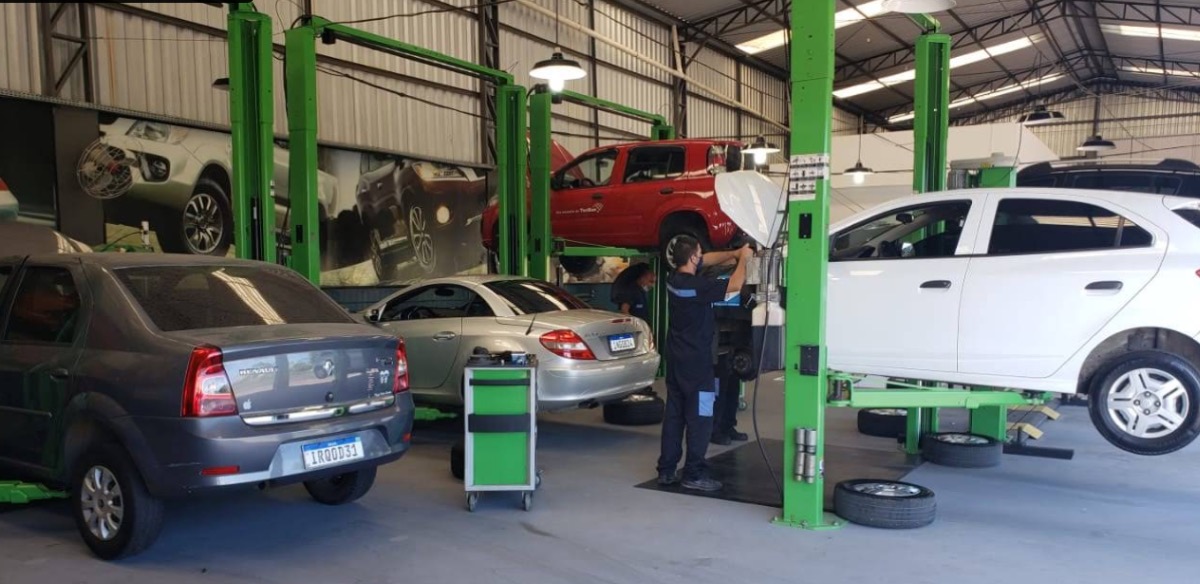 Carros erguidos em elevadores de duas colunas dentro da oficina